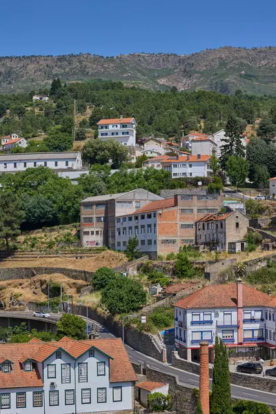 Yamaçta terk edilmiş fabrika kompleksi ve yakınlarda evler. Covilha, Portekiz - 22 Haziran 2025.