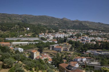 Covilha, Portekiz manzaralı yerleşim binaları, dağlar ve açık mavi gökyüzü..