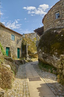 Portekiz, Monsanto 'da yeşil kapılı ve pencereli geleneksel taş evler arasındaki dar kaldırım taşı geçidi.