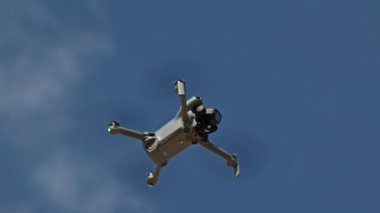 Modern DJI Mini 5 Pro Drone açık mavi gökyüzünde süzülüyor, gelişmiş hava teknolojisi ve kuadkopter tasarımı sergiliyor. Valencia, İspanya - 29 Eylül 2025.