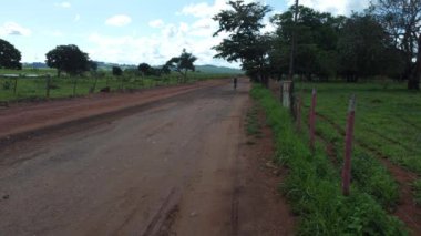 Orta yaşlı bir adam Brezilya kırsalında Goias eyaletinde Brezilya Cerrado 'da dağ bisikleti sürüyor.