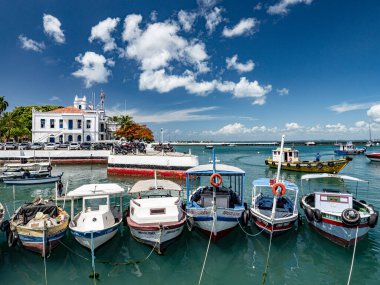 Salvador de Bahia, Brezilya. Salvador Limanı 'nda demirlemiş renkli balıkçı tekneleri ve arka planda kapitania dos portos