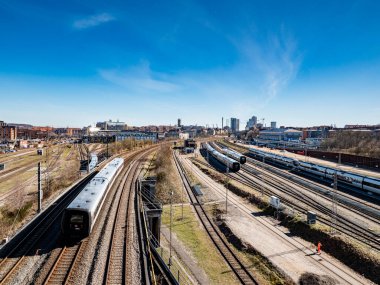 04.02.2025 Aarhus, Danimarka: Arkaplanda şehir silueti olan trenler ve raylar Aarhus, Danimarka