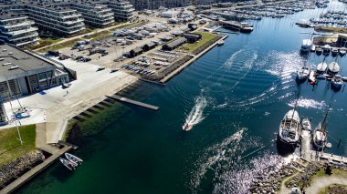 Aarhus marina ve yelkenli spor alanından bir zevk gemisi ayrılıyor. Arkaplanda Aarhus Oe 'nun bir kısmı var.