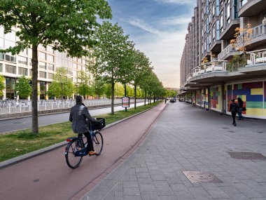Green street in Rotterdam with cyclists on a dedicated bicycle lane