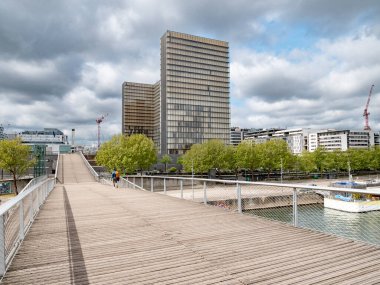 Bibliotheque Nationale de France ve Passerelle Simone-de-Beauvoir 'in manzarası Seine' i geçer ve Paris 'teki kütüphaneye gider.