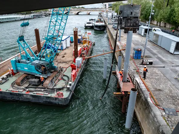 Paris, Fransa 04.14.25 Bir köprü ya da rıhtım bakım projesi kapsamında Sen Nehri 'nde destek sütunları kuran mavnadaki işçilerin ayrıntılı görüntüsü.