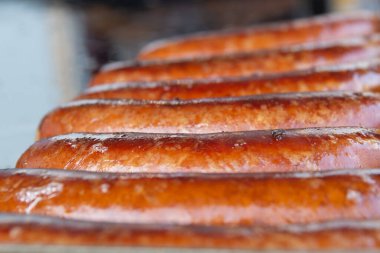 Barbekü ızgarasında Alman sosisi.