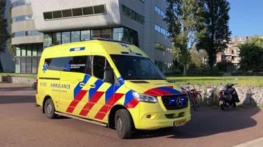 Hollanda Amsterdam - 3 Ekim 2024: Hollanda 'nın Amsterdam kentindeki şehir caddesinde ışıklar yanıp sönen ambulans