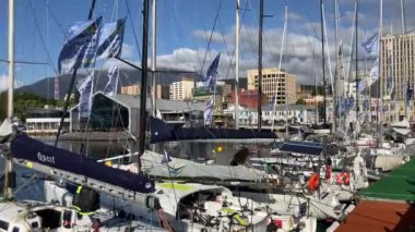 Hobart, Tazmanya, Avustralya - 28 Aralık 2022: Hobart şehri ön planda rıhtım ve yarış yatları ile ufuk çizgisi, güneşli sıcak bir günde arka planda Wellington Dağı