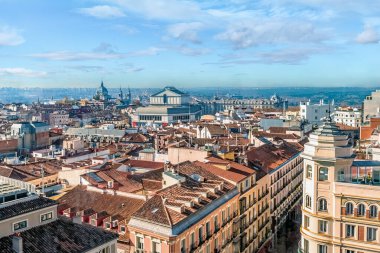 Madrid 'in panoramik manzarası, uzaktaki Kraliyet Tiyatrosu (Teatro Real) ve Almudena Katedrali. Sahne, geleneksel terracotta çatıları ve ikonik simgeler arasındaki zıtlığı yakalıyor. Madrid 'in zengin mimarisini gözler önüne seriyor.