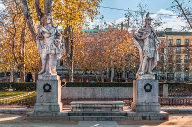 Madrid, İspanya - 30 Kasım 2021: Inigo Arista ve Kral I. Alonso 'nun heykelleri Madrid Plaza de Oriente' de. Bu tarihi heykeller, sonbahar ağaçlarıyla çevrili ve Kraliyet Sarayı yakınlarında bulunan İspanyol hükümdarlarını temsil etmektedir.