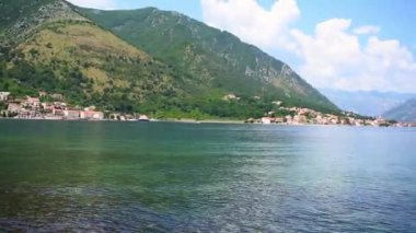 Karadağ 'ın Kotor kenti yakınlarındaki büyüleyici Dobrota köyünden yazın Kotor Körfezi' nin büyüleyici panoramik manzarası çekildi. Video 16 saniye. Kristal berrak sular, yemyeşil dağlar ve sakin bir kıyı atmosferi bu manzaralı güzelliği tanımlar.