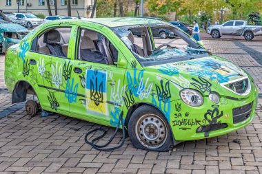Kyiv, Ukrayna - 27 Ekim 2023: Mikhailivska Meydanı, Kyiv 'deki Yok Edilmiş Rus Askeri Malzemeleri Sergisi' nde Ukrayna sembol ve graffitisiyle kaplanmış parlak ve hasarlı bir araba. Bu araba Ukrayna direnişini ve vatanseverliğini simgeliyor.