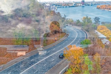 Reflective photo taken from the Glass Bridge in Kyiv, Ukraine, showing Volodymyrska Descent with a unique overlay effect of the photographer's silhouette on a rainy autumn day clipart