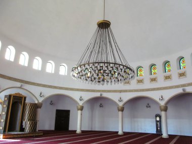 Kyiv, Ukrayna - 8 Ekim 2018: Kyiv 'deki Ar-Rahma Camii' ndeki Dua Salonu. Beyaz duvarlı büyük bir oda, kırmızı halı, güzel bir avize ve Müslüman tapınağındaki vitraylı pencereler.