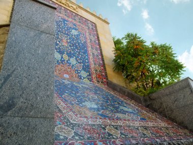 Kyiv, Ukraine - October 8, 2018: Copy of the oriental Sheikh Safi carpet from Murano glass and ceramics in Heydar Aliyev Park in Kyiv. Fragment of the wall of fountain-waterfall, side view, close-up clipart