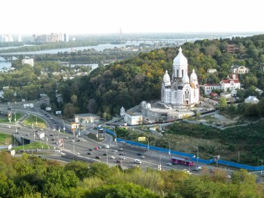 Ukraine, Kyiv - September 17, 2017: Aerial view on the Druzhby Narodiv boulevard, unfinished white Temple of Peace, Love and Unity of Christians and picturesque views of the Dnieper River. Beautiful urban landscape of the Ukrainian capital - a highwa clipart