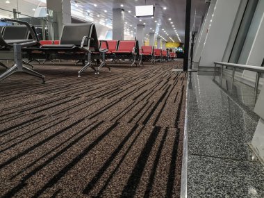 İstasyonda ya da havaalanında boş bir bekleme odasının üstündeki tavandan sarkan beyaz bir ekran. Sıralı koltukları olan salon, bilgi panosunun maketi, kopya alanı olan arkaplan