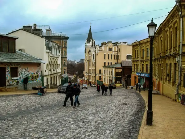 Kyiv, Ukrayna - 31 Aralık 2017: Ukrayna 'nın başkenti Andriyivskyy Descent Caddesi' nin antik masal bölgesi. Eski evler, taştan yapılmış bir yol, insanlar tırmanıyor ve bir sokak lambası kapanıyor.