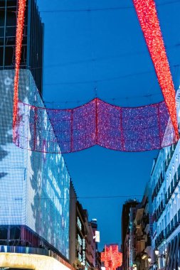 Kırmızı Noel ışığı tesisleri, Madrid sokaklarını 2021 tatil sezonunda süslemektedir. Parlak LED ekranlar festival gece sahnesine modern bir dokunuş ekler. Madrid, İspanya - 30 Kasım 2021