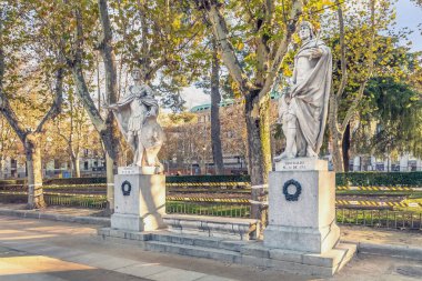 Madrid, Spain - November 30, 2021: Marble statues of Suintila and Leovigildo, two ancient kings of Spain, stand tall in Plaza de Oriente, Madrid. These detailed sculptures are surrounded by autumn foliage clipart