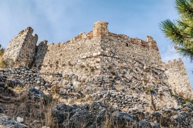 Türkiye 'nin Alanya Kalesi (Alanya Kalesi) antik taş duvarlarının yakın plan görüntüsü. Tarihi kale kayalık bir tepenin tepesinde, eskimiş yapısını ve zamansız mimarisini gözler önüne seriyor.