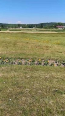 Ukrayna 'nın Sumy Oblastı, Pustoviitivka köyündeki yaz manzaralarının dairesel panoramik manzarası. Dikey 4K video 13 saniye. Sahne, arka planda yeşilliklerle çevrili Aziz Niklas Kilisesi 'ne ait.