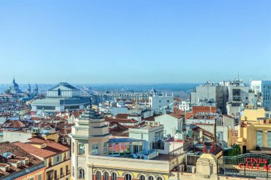 Madrid, İspanya - 30 Kasım 2021: Kraliyet Tiyatrosu ve tarihi binaların çatılarının yer aldığı panoramik bir Madrid şehir manzarası. Ufuk çizgisi, İspanya başkentinin mimari cazibesini sergileyerek uzak ufka doğru uzanıyor.