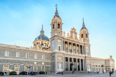 Madrid 'deki Almudena Katedrali, neoklasik mimari tarzını ikiz çan kuleleri ve etkileyici kubbesi ile sergiliyor. Ön cephede heykeller ve karmaşık detaylar yer alıyor. Madrid, İspanya - 30 Kasım 2021