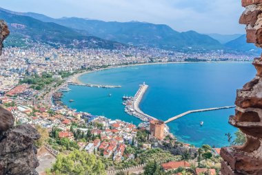 Alanya kıyı şeridi ve Kızıl Kule 'nin manzarası, Alanya Kalesi' ndeki yüksek bir noktadan çekildi. Akdeniz ve marina kentle çarpıcı bir tezat oluşturuyor.