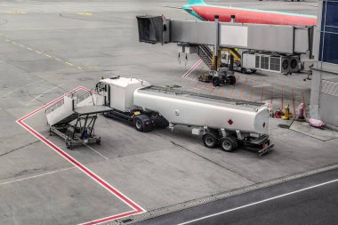 Ukrayna, Kyiv 'deki Boryspil Uluslararası Havalimanı' nda uçak yakıt ikmali makinesi. Yol işaretli beton bir pistte merdiven, kamyon ve diğer ekipmanlar - üst görünüm