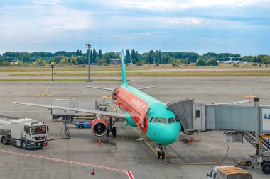 Kyiv, Ukrayna - 16 Haziran 2021: Kyiv yakınlarındaki Boryspil havaalanında WindRose uçağının bakımı. Jet Köprüsü ve servis araçları pistteki bir uçağın yanında.