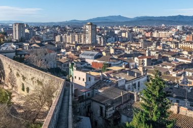 Tarihsel şehir duvarlarından Girona 'nın panoramik manzarası İspanya' nın eski kasabası ve modern binaları arasındaki zıtlığı gösteriyor. Antik taş tahkimatı, arka planda dağlar olan terasotta çatılarına bakar.