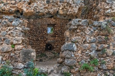 Türkiye 'nin Alanya Şatosu' ndaki antik taş bir yapının kalıntıları. Yıpranmış taş duvarlar ve küçük pencere bu kalenin tarihsel önemini vurguluyor.