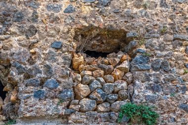 Türkiye 'nin Alanya Şatosu' nun duvarında taşlarla dolu eski bir pencere. Bu ayrıntı ortaçağ kalesinin yıpranmış, tarihi mimarisini gözler önüne seriyor.