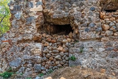 Türkiye 'nin Alanya Şatosu' nun yıpranmış duvarında taş dolu antik bir pencere. Bu resim ortaçağ kalesinin kırsal ve tarihi mimarisini vurgular.