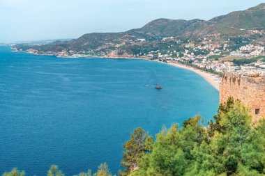 Alanya Şatosu 'ndan nefes kesici manzara, Kleopatra Sahili ve Akdeniz' in berrak mavi sularını gözler önüne seriyor. Kalenin tarihi taş duvarları huzurlu kıyı manzarasına derinlik katar.