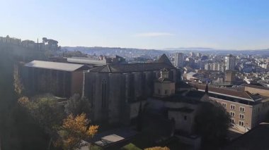 Girona kale duvarındaki dairesel manzara ortaçağ mimarisi ve sonbahar tepelerini yansıtıyor. Video 26 saniye. Sabah ışığı tarihi cazibeyi modern şehir manzaraları ve uzak dağlarla harmanlıyor.