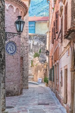 Karadağ 'ın Kotor kentinde tarihi binalar ve hediyelik eşya dükkanlarıyla dolu dar bir ara sokak. Büyüleyici eski kasaba sokakları şehrin geleneksel mimarisini ve dingin atmosferini yansıtıyor. Kotor, Karadağ - 18 Haziran 2021