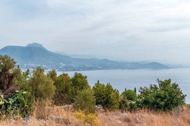 Türkiye 'nin Alanya Şatosu' ndan sakin kıyı şeridine ve uzak dağlara bakan manzara. Yeşillik ve Akdeniz, doğanın güzelliğine bir göz atmak için huzurlu bir manzara yaratıyor.
