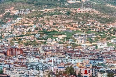 Türkiye 'nin Alanya kentinin panoramik manzarası. Manzarayı kaplayan yerleşim binaları ve arka plandaki tepede 