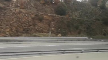 İspanya 'nın Katalonya kentindeki bir otobüs penceresinden dinamik bir yolculuk manzarası, sonbahar tepeleri ve ağaçlar hızla akıyor. Video 45 saniye. Hareket bulanıklığı hareketli bir otoyol yolculuğunun hızını ve hareketini yakalar