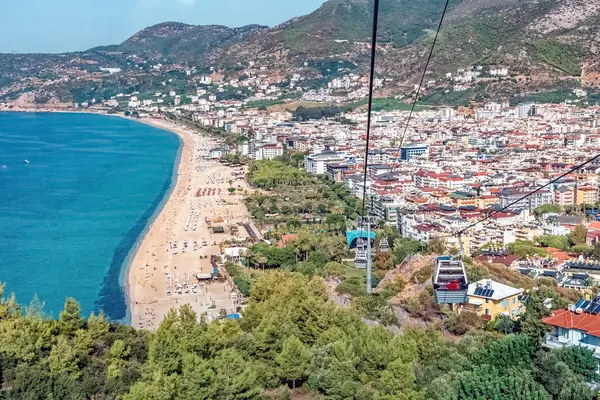 Teleferik gezisi Kleopatra Sahili ve Türkiye 'nin Alanya kenti için çarpıcı bir hava manzarası sunuyor. Güzel Akdeniz kıyı şeridi şehrin canlı şehir manzarası boyunca uzanır.