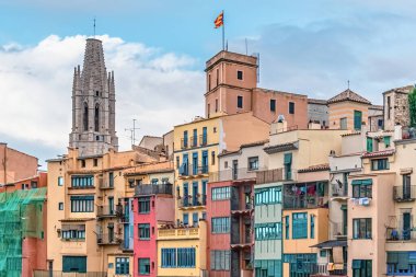 Renkli binalar, Katedral kulesi ve Katalan bayrağının yer aldığı Girona şehir manzarası. İspanya 'nın tarihi Katalonya kentindeki mimari detaylar
