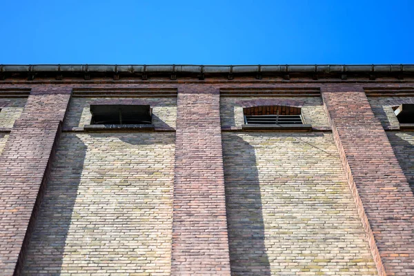 stock image House wall made of different colored bricks in low angel and blue Sky