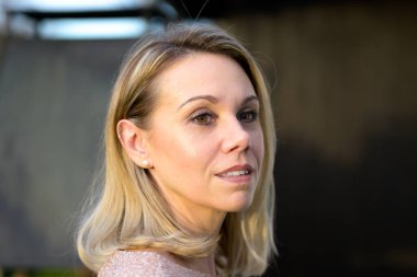 Side view of a gorgeous attractive blond woman in her fourties with a gentle smile