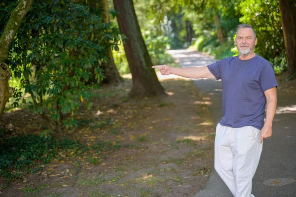 Middle Aged Man Walking Country Road Shady Trees Pointing Side — Stock Photo, Image