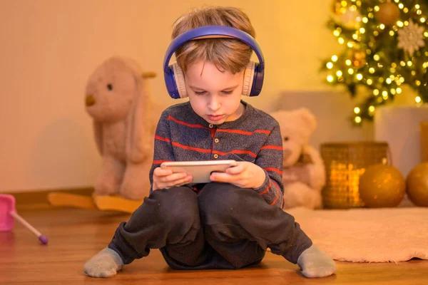 Det Femåriga Barnet Sitter Vardagsrummet Med Hörlurar Och Leker Med — Stockfoto