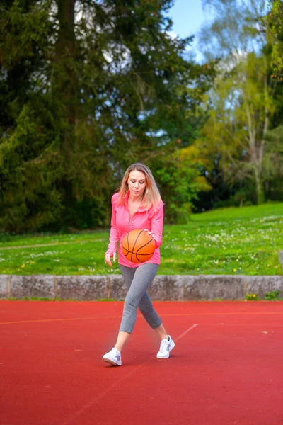 Atraktivní Blondýny Žena Dribbles Soustředil Basketbal Sportovní Hřiště — Stock fotografie